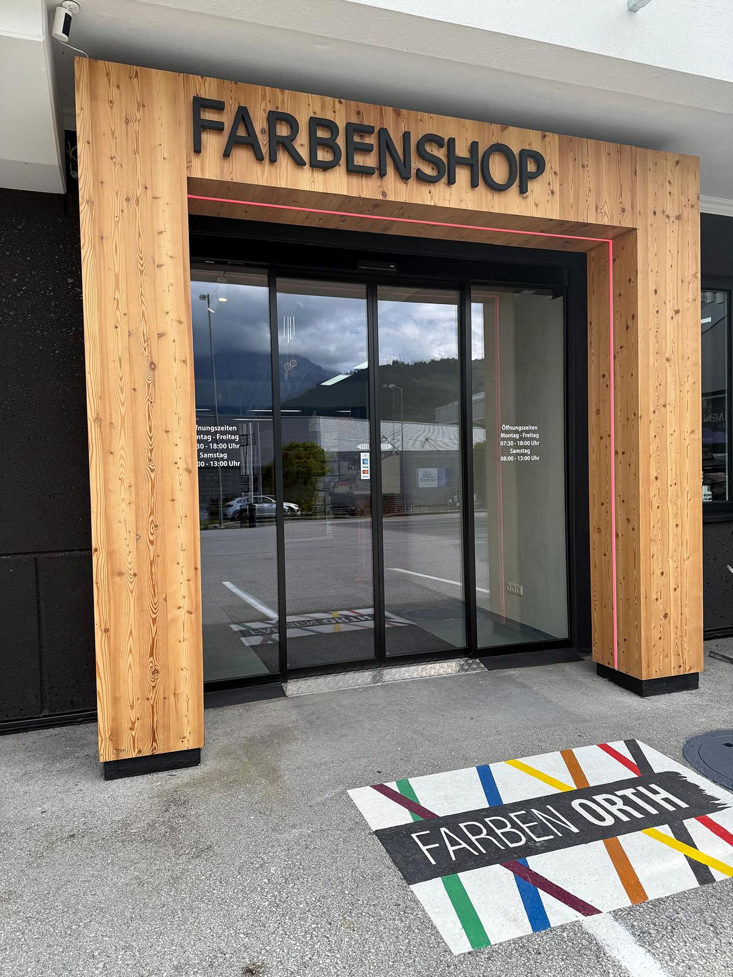 Eingang Farbenshop Farben Orth mit Bodenlogo und Öffnungszeiten