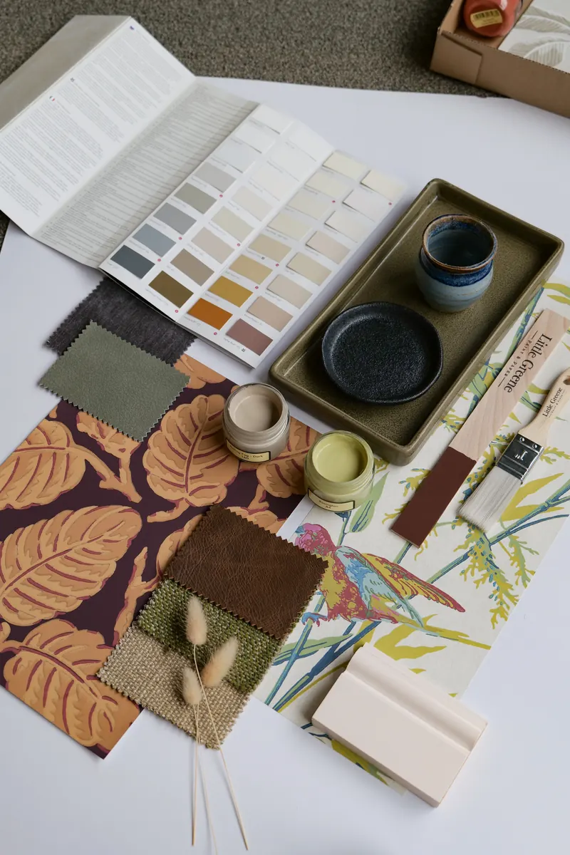Moodboard mit Farbkarte und Musterdosen in warmen Tönen